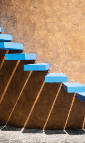 A set of blue steps leading up to a brown wall. Description generated by AI