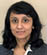 A woman wearing a suit and a gold necklace. Description generated by AI