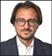 Man wearing a blue jacket and white shirt. Description generated by AI