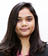 A woman wearing a pink shirt and black suit. Description generated by AI
